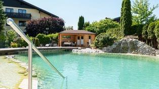 großer Schwimmteich mit Gartenhaus im Hotel Himmelreich in Salzburg