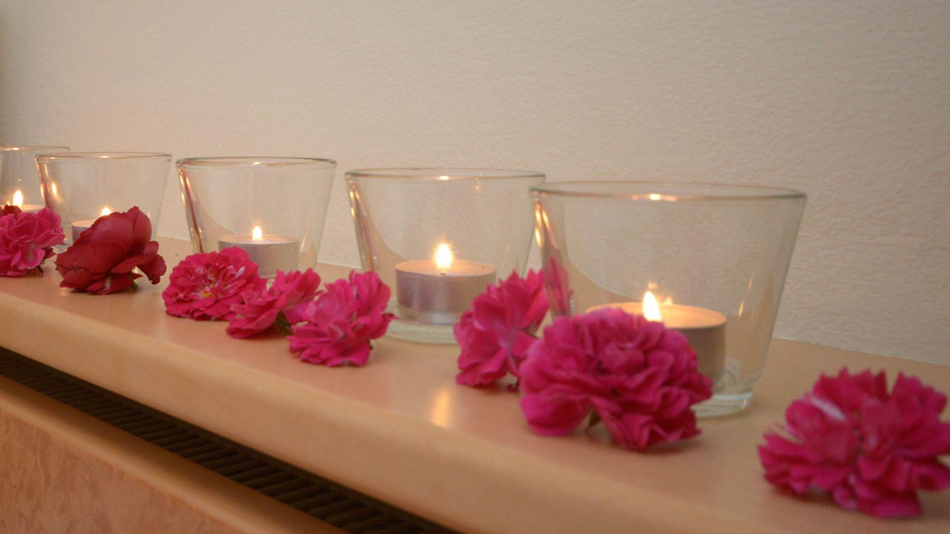 romantische Zimmerdekoration mit Kerzen und Rosenblätter